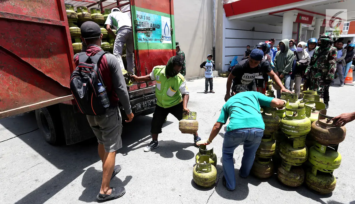 Petugas menurunkan tabung gas elpiji 3 kg saat operasi pasar elpiji di SPBU Ki Hajar Dewantara di Palu, Sulawesi Tengah, Senin (8/10). Pertamina melakukan operasi pasar elpiji 3 kg dan 12 kg. (Liputan6.com/Fery Pradolo)