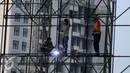 Pekerja mengelas rangkaian besi untuk pembuatan papan reklame di jalan Gadjah Mada, Jakarta, Selasa (13/12). Pemerintah DKI Jakarta akan menyusun rencana penataan terhadap reklame yang tidak beraturan di jalur protokol. (Liputan6.com/Gempur M. Surya)