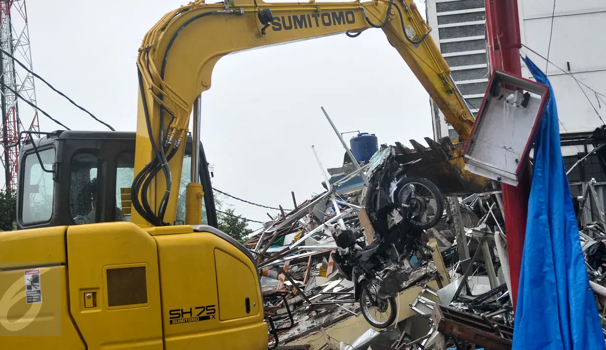 Alat berat mengangkat sebuah motor yang hancur tertimpa puing bangunan PHD, Kota Bekasi, Minggu (23/10). Satu unit eskavator milik Dinas Bina Marga dan Tata Air (Disbimarta) Kota Bekasi dipinjamkan ke lokasi ledakan. (Liputan6.com/Yoppy Renato)