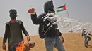 Warga Palestina bersiap menerbangkan layang-layang yang telah diberikan bom molotov di atas pagar perbatasan dengan Israel, di pinggiran timur Kota Gaza (20/4). Unjuk rasa warga Palestina terhadap Isrel memasuki minggu keempat. (AFP Photo/Mohammed Abed)