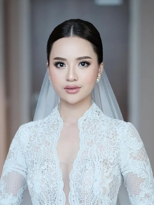 Blush on dipilih nuansa coral yang segar, sementara bibir dibuat plup glossy warna soft mauve.  [@anggimarito]