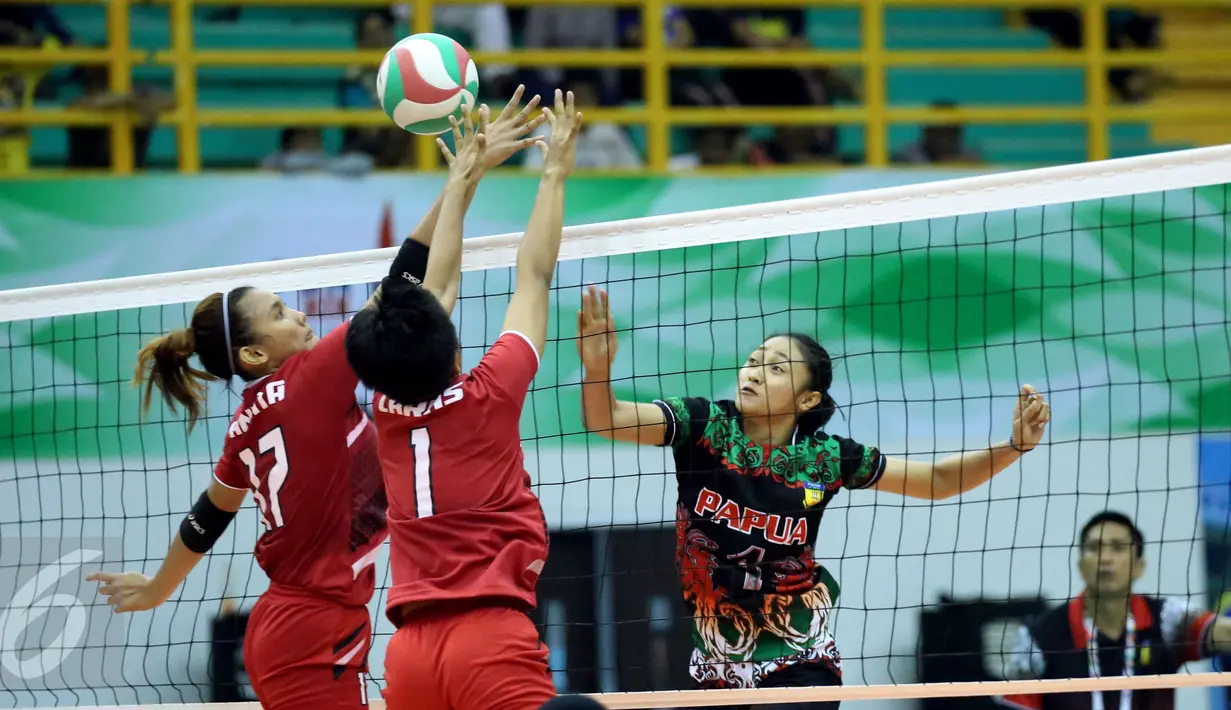 Pevoli putri Papua, Putri Lestari (kanan) melakukan smes saat laga melawan DKI Jakarta di fase grup Y PON XIX Jabar di Gelora Sabilulungan, Kab Bandung, Rabu (21/9). DKI Jakarta unggul tiga set (25-21, 25-21, 25-19). (Liputan6.com/Helmi Fithriansyah)