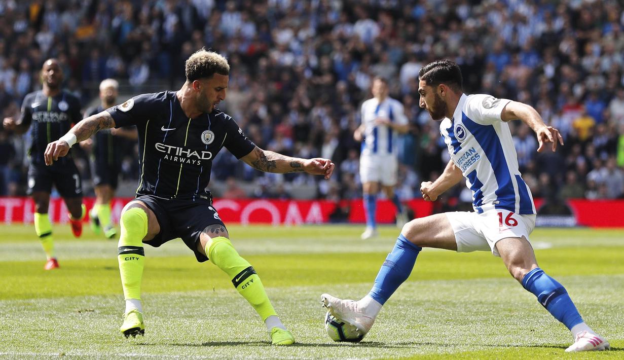 Bek Manchester City, Kyle Walker, menghadang pemain Brighton and Hove Albion, Alireza Jahanbakhsh, pada laga Premier League di Stadion AMEX, Minggu (12/5). Manchester City menang 4-1 atas Brighton and Hove Albion. (AP/Frank Augstein)