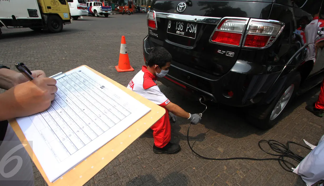 Petugas terlihat mencatat hasil pengujian gas buang salah satu kendaraan saat uji emisi di Jalan Proklamasi, Jakarta, Selasa (6/10/2015). Uji emisi gratis tersebut bertujuan untuk mengevaluasi kualitas udara perkotaan. (Liputan6.com/Immanuel Antonius)