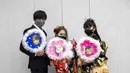 Keita Daisen, Sara Watanabe dan Honoka Watanabe berusia 20 tahun dari Jepang (kiri ke kanan) mengenakan kimono dan berpose di luar Todoroki Arena selama upacara perayaan "Coming-of-Age Day" di Kawasaki, prefektur Kanagawa (11/1/2021). (AFP/Behrouz Mehri)