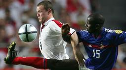Wayne Rooney berusaha melewati hadangan bek Prancis, Lilian Thuram, pada laga Piala Eropa di Estadio da Luz, Portugal, Minggu (13/6/2004). (AFP Photo/Frank Fife)