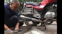 Meski buta Zhu Shuyou dapat memperbaiki sepeda motor dengan cara mendeteksi masalah dari getaran dan suara mesin. (Shanghaiist)
