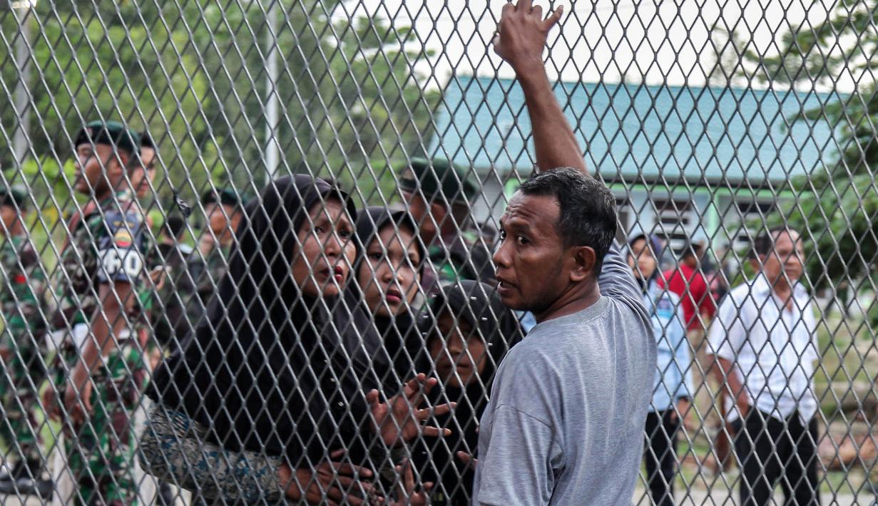 Narapidana bertemu dengan keluarganya setelah kerusuhan di Lapas Narkotika Kelas III Langkat, Sumatera Utara, Kamis (16/5/2019). Akibat peristiwa kerusuhan yang dilakukan para narapidana di Lapas itu mengakibatkan tiga mobil petugas rusak terbakar dan ratusan napi melarikan diri. (Ivan Damanik/AFP)
