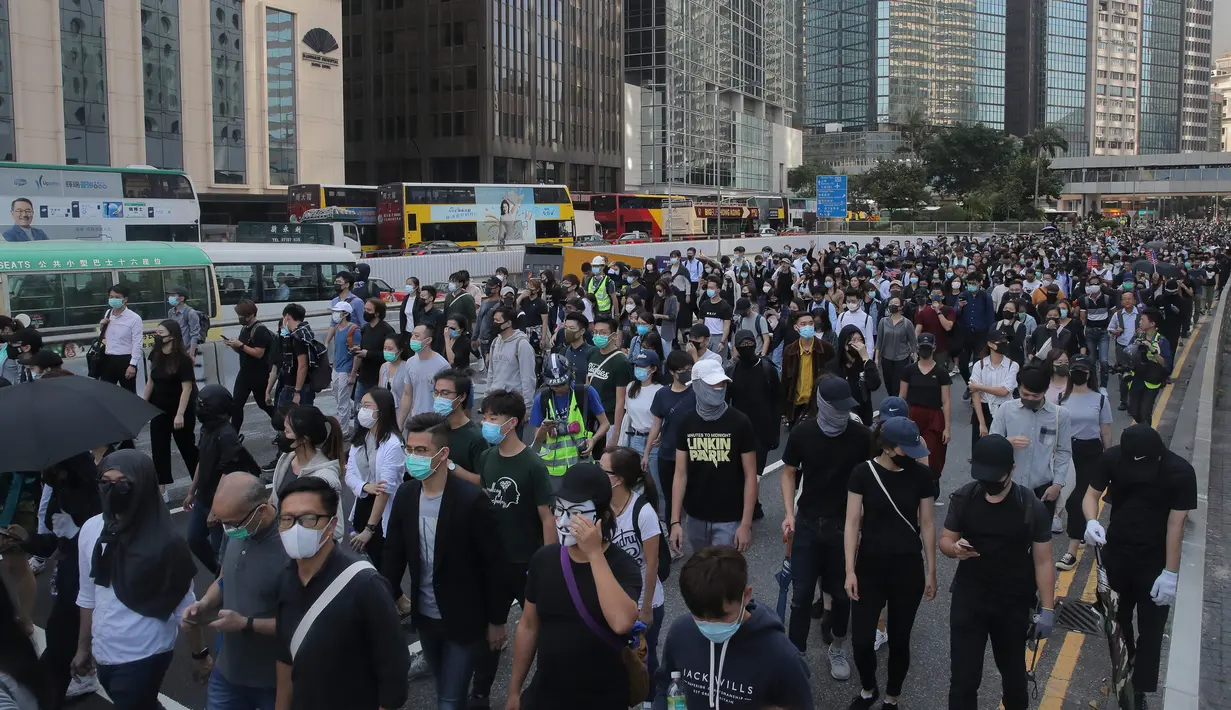 Demonstran berbaris dan memblokir jalan di Distrik Central, Hong Kong, Senin (11/11/2019). Ketegangan di Hong Kong semakin meningkat setelah polisi menembak seorang demonstran hingga kritis. (AP Photo/Kin Cheung)