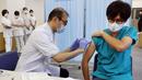 Seorang pria (kanan) menerima dosis ketiga vaksin COVID-19 Pfizer di Nagoya, prefektur Aichi, Rabu (1/12/2021). Jepang mulai memberikan suntikan booster COVID-19 kepada petugas medis di tengah kekhawatiran atas varian omicron yang telah terdeteksi di negara itu. (STR /JIJI PRESS/ AFP)