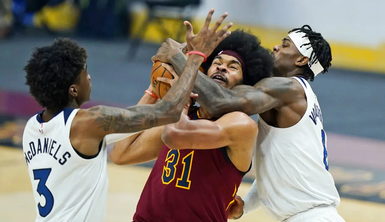 Pebasket Cleveland Cavaliers, Jarrett Allen, berebut bola dengan pebasket Minnesota Timberwolves, Jarred Vanderbilt dan Jaden McDaniels pada laga NBA di Rocket Mortgage FieldHouse, Senin (1/2/2021). Cavaliers menang dengan skor 100-98. (AP/Tony Dejak)