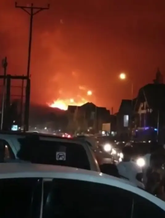 Orang-orang menyaksikan Gunung Nyiragongo yang meletus di Goma, Kongo, Sabtu (22/5/2021). Gunung Nyiragongo di Kongo meletus untuk pertama kalinya dalam hampir dua dekade pada Sabtu, mengubah langit malam menjadi merah menyala dan mengirimkan lahar ke jalan raya utama. (@officialraphaelileso via AP)