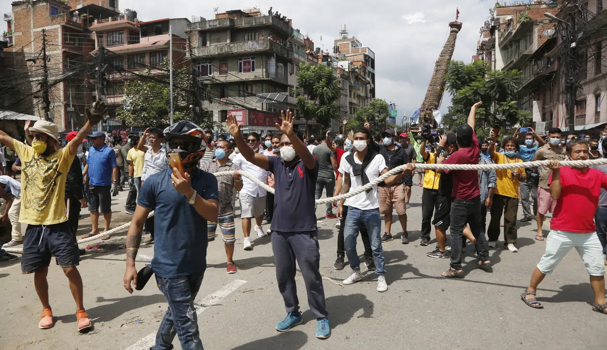 Warga Nepal saat bentrok dengan aparat kepolisian yang menghentikan kereta Dewa Rato Machhindranath dalam sebuah festival keagamaan di Lalitpur, Nepal (3/9/2020). (AP Photo/Niranjan Shrestha)