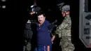 Tentara Meksiko mengawal ketat gembong narkoba Joaquin "El Chapo" Guzman di kantor Kejaksaan Agung, Meksiko (8/1/2016). Joaquin "El Chapo" Guzman melarikan diri dari penjara melalui terowongan yang ia buat pada 11 Juli 2015. (REUTERS/Tomas Bravo)