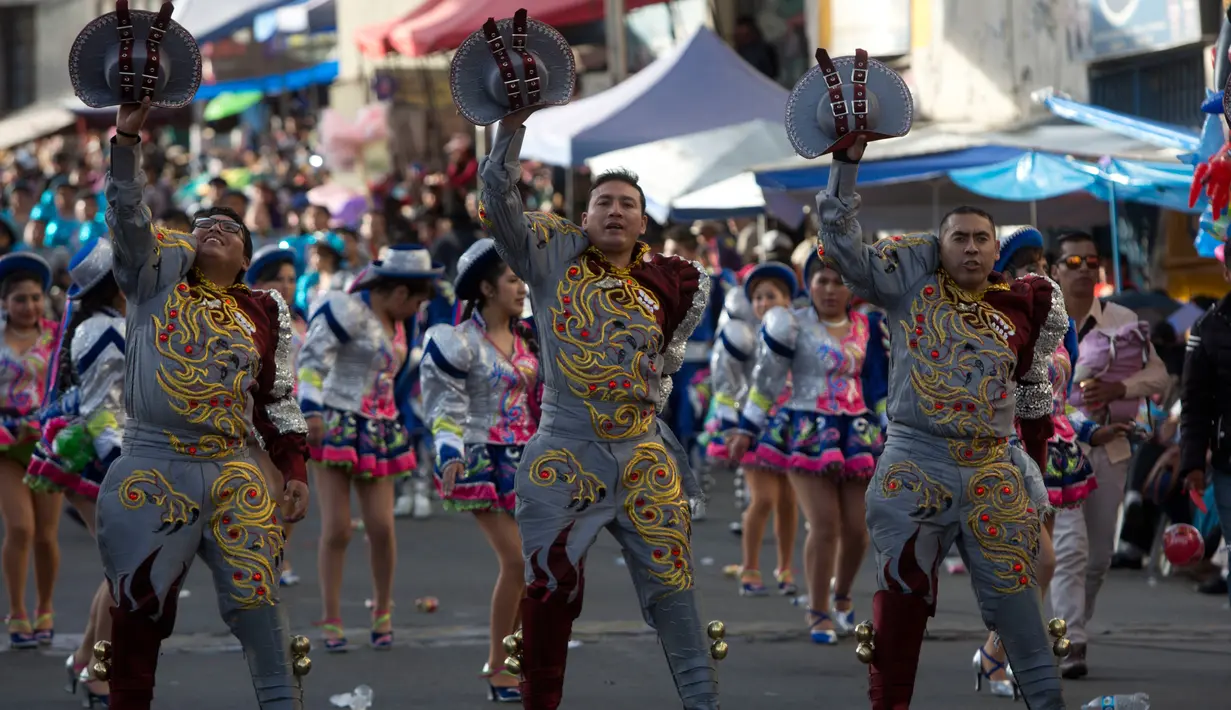 Tiga orang pria melakukan gerakan tari saat mengisi parade tahunan untuk menghormati "El Senor del Gran Poder" atau "The Lord of Great Power" di La Paz, Bolivia (10/6). (AP Photo / Juan Karita)