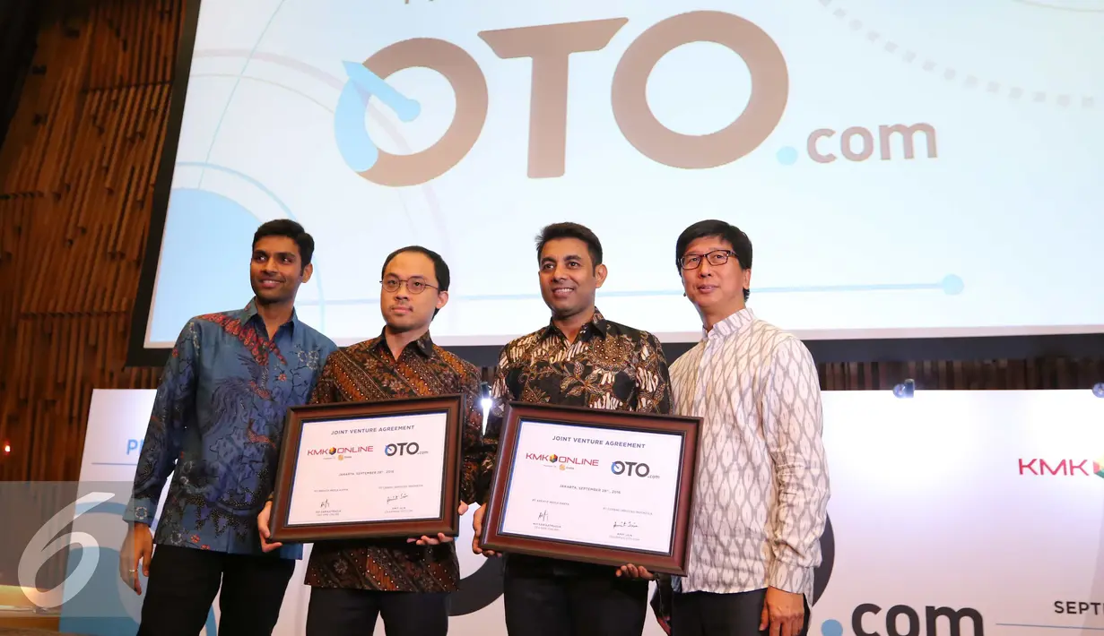 CEO KMK Online, Adi Sariaatmadja (kedua kiri) dan CEO Girnar Soft Amit Jain (kedua kanan) memperlihatkan piagam kerjasama saat peluncuran Oto.com di Jakarta, Rabu (28/9).(Liputan6.com/Angga Yuniar)