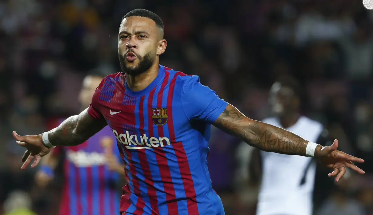 Penyerang Barcelona, Memphis Depay berselebrasi usai mencetak gol ke gawang Valencia pada pertandingan lanjutan La Liga Spanyol di stadion Camp Nou,Spanyol, Senin (18/10/2021). Kemenangan ini mengantar Barcelona berada di peringkat ketujuh klasemen dengan 15 poin. (AP Photo/Joan Monfort)