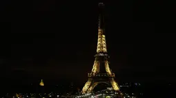 Lampu Menara Eiffel di Paris dipadamkan sebagai penghormatan kepada korban serangan teroris di Masjid Bir el-Abd, Semenanjung Sinai, Mesir (24/11). Wali Kota Paris mengatakan, menara Eifel akan menjadi gelap pada tengah malam. (AFP Photo/Thomas Samson)