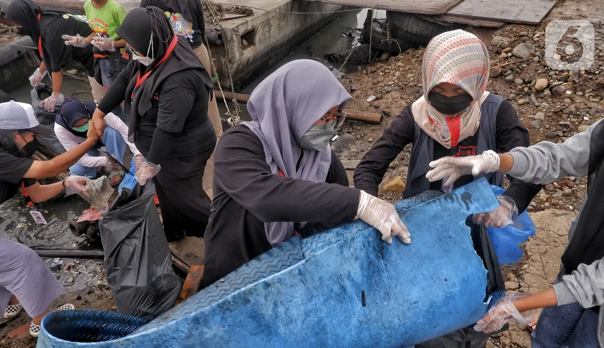 Sukarelawan Kelas Jurnalis Cilik saat membersihkan sampah di kawasan Cilincing, Jakarta Utara, Minggu (5/12/2021). Kegiatana ini guna mengurangi sampah yang berdatangan akibat banjir rob. (merdeka.com/Iqbal S. Nugroho)