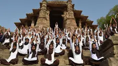 Siswa sekolah India mengambil bagian dalam sesi yoga untuk menandai Hari Yoga Internasional di Kuil Matahari di Modhera, dekat kota Mahesana sekitar 100 km dari Ahmedabad di negara bagian Gujarat, (21/6). (AFP Photo/Sam Panthaky)