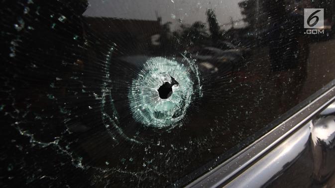 Bekas tembakan peluru pada kaca mobil saat gelar perkara kasus pembobolan toko di Polsek Pamulang, Jumat (19/10). Komplotan yang berjumlah empat orang itu merampok sebuah toko sembako. (Merdeka.com/Arie Basuki)