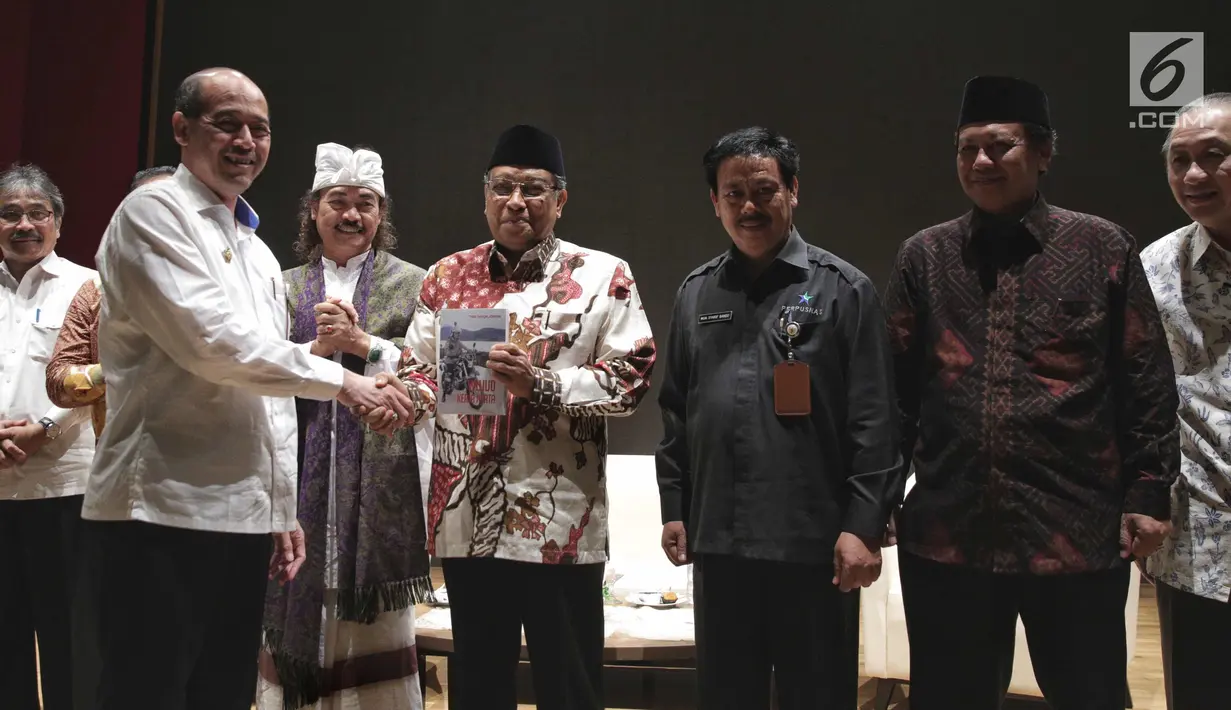 Ketua Umum Nawacita Jokowi, Mas Raden Suryo Admanto memberikan buku kepada Ketua Umum PBNU Said Aqil Siradj saat peluncuran buku tiga tahun Jokowi di Perpustakaan Nasional, Jakarta, Senin (6/11). (Liputan6.com/Faizal Fanani)