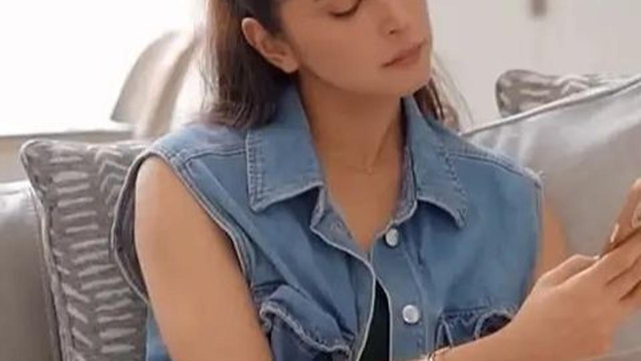 Di bagian tengah rumah, sofa mewah menghadap tangga menuju lantai dua. Nabila santai di sofa tersebut.