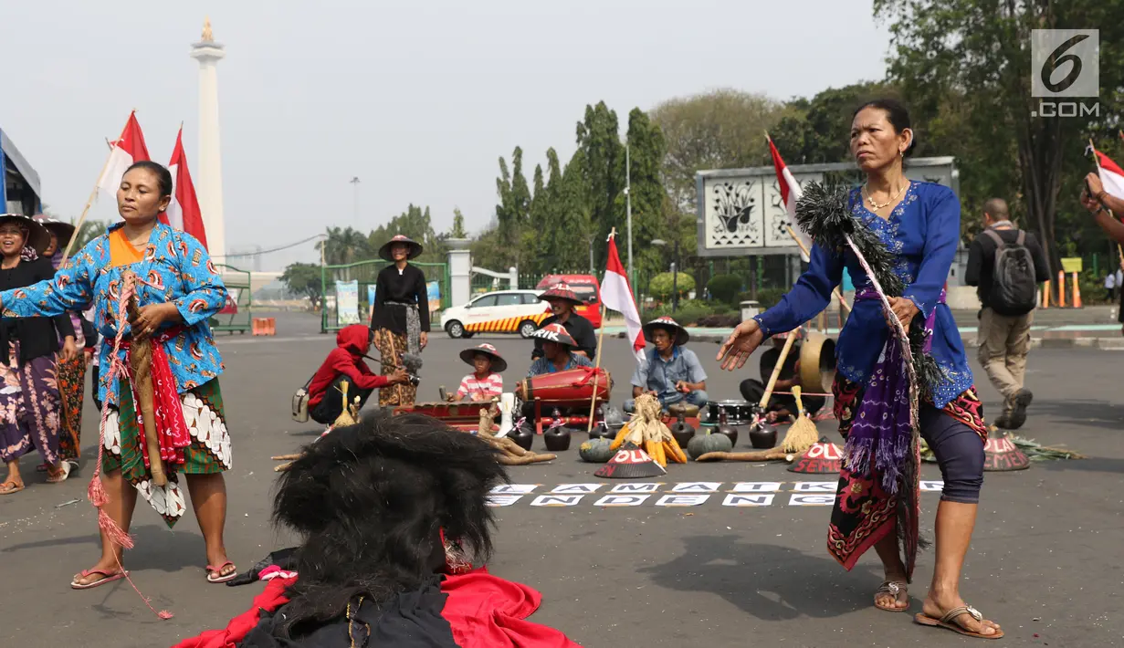 Dua perempuan Kendeng menari saat aksi di depan Istana Negara, Jakarta, Kamis (2/8). Dalam aksinya, mereka melakukan tradisi Brokohan memperingati pertemuan mereka dengan Presiden Jokowi. (Liputan6.com/Helmi Fithriansyah)