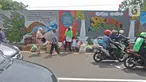 Pejalan kaki dan warga melintasi mural yang berisi pesan ajakan untuk menjaga lingkungan di Jalan Tambak, Manggarai, Jakarta, Selasa (11/2/2020). Mural tersebut bertujuan mengingatkan bahwa permasalahan lingkungan merupakan masalah serius yang harus dihadapi bersama. (Liputan6.com/Herman Zakharia)