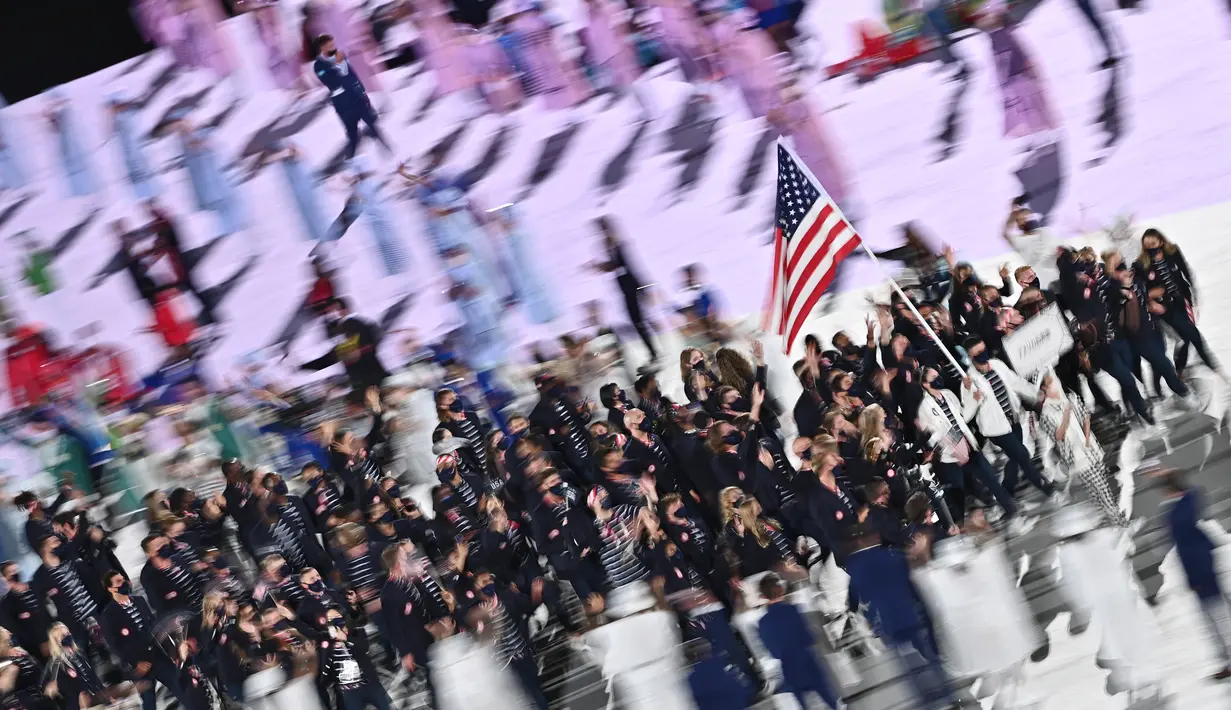 Pembawa bendera Amerika Serikat Sue Bird (kedua kanan) dan Eddy Alvares memimpin delegasi saat upacara pembukaan Olimpiade Tokyo 2020, di Olympic Stadium di Tokyo, Jumat (23/7/2021). Upacara pembukaan Olimpiade Tokyo yang berlangsung dalam era pandemi digelar tanpa penonton. (Jeff PACHOUD / AFP)