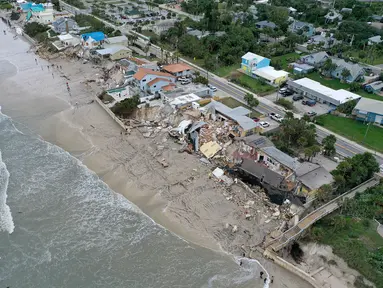 Pandangan dari udara menunjukkan sebagian rumah terguling ke pantai setelah Badai Nicole mendarat di Pantai Daytona, Florida (10/11/2022). Badai Nicoler datang ke darat sebagai badai Kategori 1 sebelum melemah menjadi badai tropis saat bergerak melintasi negara bagian. (Joe Raedle/Getty Images/AFP)