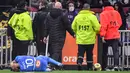 Pemain Olympique de Marseille Dimitri Payet jatuh setelah terkena botol air yang dilemparkan oleh seorang suporter, di Stadion Groupama, Lyon, Prancis, Minggu (21/11/2021). (AFP/Philippe Desmazes)