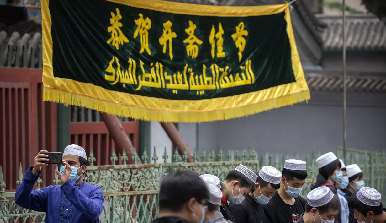 Umat Muslim berkumpul di luar Masjid Niujie sebelum sholat Idul Fitri di Beijing, Kamis (13/5/2021). Umat Muslim merayakan Idul Fitri dengan suasana hati yang tenang untuk tahun kedua Kamis karena pandemi COVID-19 yang kembali memaksa penutupan masjid. (AP Photo/Mark Schiefelbein)