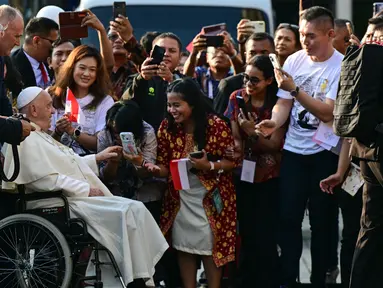 Paus Fransiskus menyapa para jemaat saat tiba di Katedral Bunda Maria Diangkat ke Surga, Jakarta pada 4 September 2024. (Tiziana FABI/AFP)