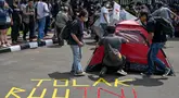 Para mahasiswa memprotes agenda pengesahan Revisi Undang-Undang (RUU) Tentara Nasional Indonesia (TNI) menjadi Undang-Undang di depan gedung Parlemen RI di Jakarta pada tanggal 20 Maret 2025. (BAY ISMOYO/AFP)