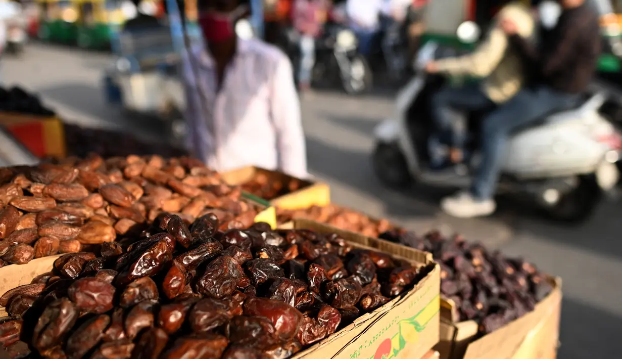 Kurma dan buah-buahan kering dipajang di rak-rak toko di sepanjang jalan untuk bulan suci Ramadhan di Delhi, India pada Selasa (13/4/2021). Kurma sangat identik dengan bulan Ramadhan, karena buah yang satu ini kerap dijadikan pengisi menu sahur dan berbuka puasa. (Sajjad HUSSAIN / AFP)