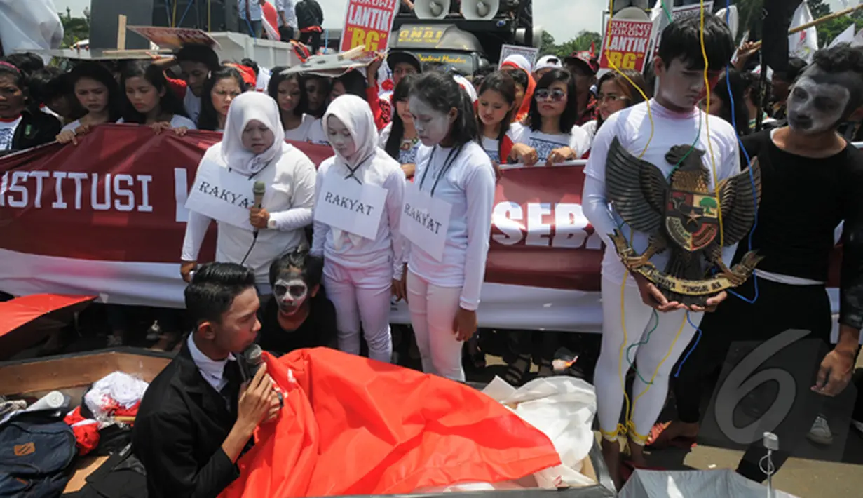 Seorang demonstran yang berada di dalam peti melakukan aksi teatrikal di depan Istana Merdeka, Jakarta, Senin (16/2/2015). Aksi teatrikal untuk mendesak Presiden Jokowi untuk melantik Budi Gunawan sebagai kapolri. (Liputan6.com/Herman Zakharia). 