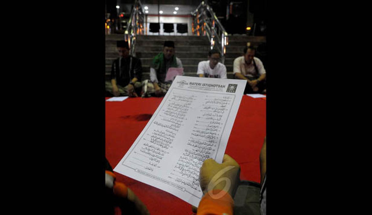 Sejumlah masyarakat menggelar istighosah di halaman Gedung KPK, Jakarta, Minggu (1/2/2015). Tampak selembar kertas doa sedang dibaca saat istighosah sebagai bentuk dukungan kepada Komisi Pemberantasan Korupsi (KPK)‎. (Liputan6.com/Andrian M Tunay)