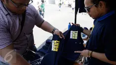 Calon pembeli melihat baju bertulisan "Turn Back Crime" yang dijual saat Car Free Day dikawasan Bunderan HI, Jakarta, Minggu (13/3). Penggunaan merk 'Turn Back Crime' bertujuan untuk kampanye waspada tindak kejahatan. (Liputan6.com/Faizal Fanani)