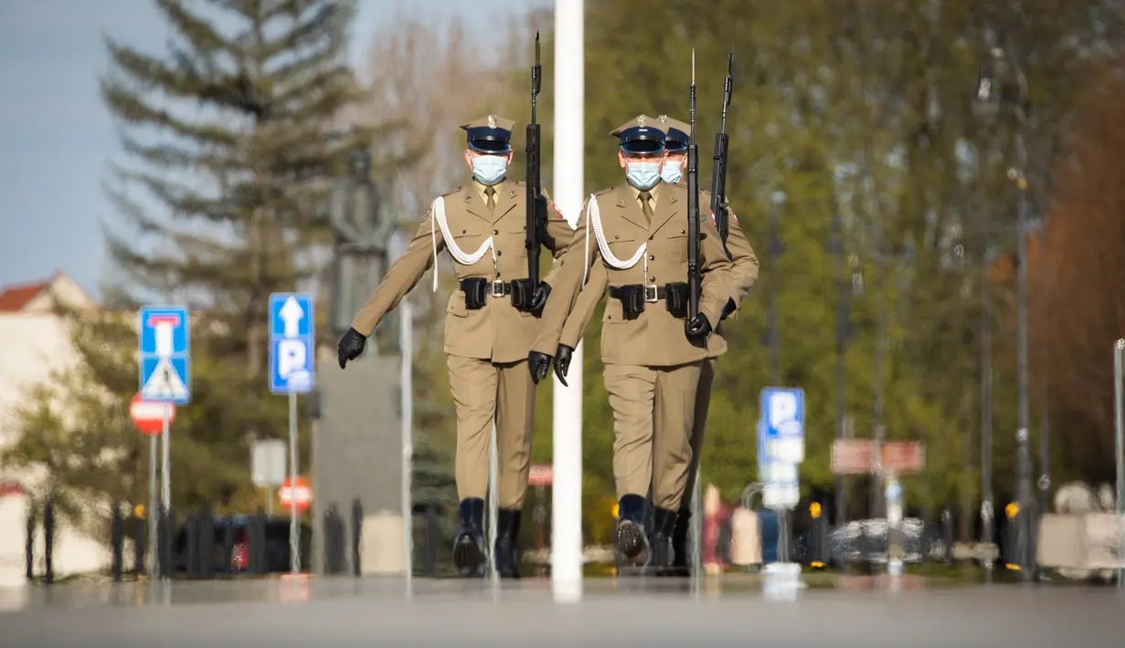 Para tentara yang mengenakan masker melakukan pertukaran sif di Makam Prajurit Tak Dikenal di Warsawa, Polandia (20/4/2020). Pemerintah Polandia telah melonggarkan beberapa kebijakan pembatasan terkait pandemi COVID-19 pada Senin (20/4). (Xinhua/Jaap Arriens)