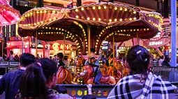 Sejumlah anak bermain wahana kuda putar di Skytropolis Funland di resor Genting Highlands, Kuala Lumpur, Malaysia (30/6/2019). Cuaca di Genting Highlands relatif sejuk dengan temperatur tidak lebih dari 30 °C dan jarang turun di bawah 15 °C setiap tahunnya. (AFP Photo/Mohd Rasfan)