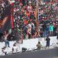 Sejumlah suporter berada di sekitar pagar besi tribun Jakarta International Stadium (JIS) yang rusak di Jakarta, Minggu (24/7/2022). Pagar di sisi utara stadion tingkat dunia tersebut roboh akibat diduduki oleh para penonton. (Liputan6.com/Herman Zakharia)
