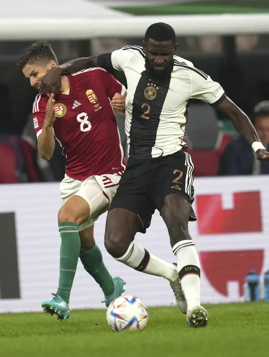 Bek Jerman, Antonio Rudiger berebut bola dengan pemain Hungaria Adam Nagy selama pertandingan UEFA Nations League di Red Bull Arena di Leipzig, Jerman, Jumat, 23 September 2022. Dengan hasil ini, Jerman turun peringkat ke posisi tiga Grup 3 dengan enam poin dari lima pertandingan. (AP Photo/Michael Sohn)