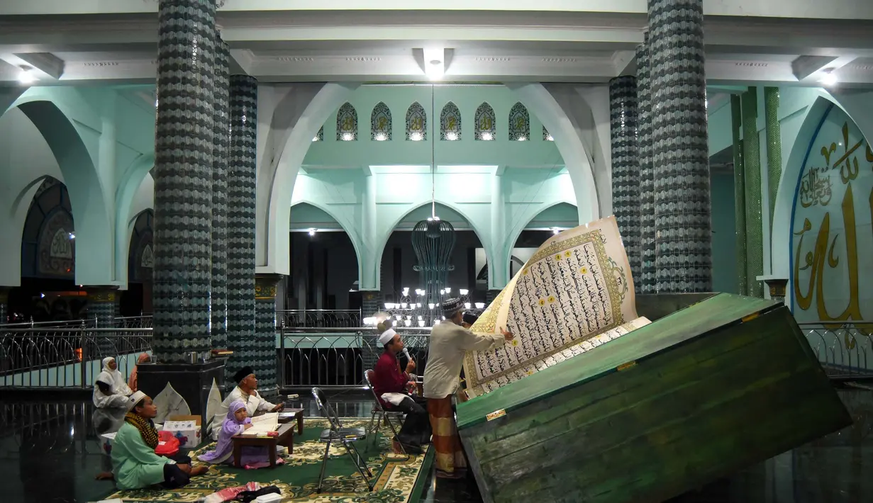 Umat Islam usai salat tarawih di Masjid Baiturrahman, Banyuwangi, secara rutin membaca Al-Quran raksasa. (Noly Falah/AFP)