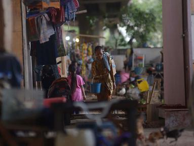 Penjual jamu gendong melintasi permukiman warga di Kawasan Penjaringan, Jakarta, Sabtu (23/11/2019). Bank Dunia mengukur tingkat kemiskinan dengan batas Upper Middle-Income Clas atau kelas menengah mempunyai pendapatan US$ 5,5 atau setara Rp 77 ribu per hari. (merdeka.com/Imam Buhori)