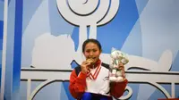 Atlet Bali, Ni Nengah Widiasih, menggigit medali emas usai menjadi juara pada pada kelas 41 kg putri cabang olahraga angkat berat Peparnas 2016 di Hotel Preanger, Bandung, Jawa Barat, Selasa (18/10/2016) (pon-peparnas2016jabar.go.id)