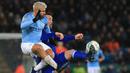 Striker Manchester City, Sergio Aguero, berebut bola dengan bek Leicester, Christian Fuchs, pada laga Piala Liga di Stadion King Power, Leicester, Selasa (18/12). Leicester kalah adu penalti dari City. (AFP/Lindsey Parnaby)