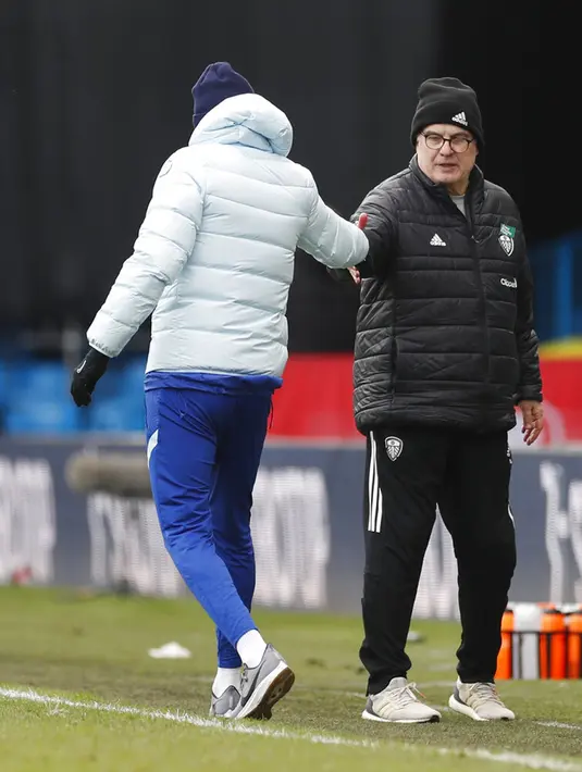 Pelatih kepala Leeds United Marcelo Bielsa (kanan) berjabat tangan dengan pelatih kepala Chelsea Thomas Tuchel pada akhir pertandingan Liga Inggris di Stadion Elland Road, Leeds, Inggris, Sabtu (13/3/2021).  Pertandingan berakhir 0-0. (Lee Smith/Pool via AP)