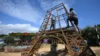 Para pekerja membangun model replika Menara Eiffel di sebuah taman di Puducherry, sebuah wilayah bekas koloni Prancis di India pada tanggal 18 Januari 2024. (Arun SANKAR/AFP)