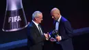 Pelatih Real Madrid, Zinedine Zidane bersalaman dengan Claudio Ranieri setelah meraih penghargaan pelatih terbaik pada acara The Best FIFA Football Awards 2017 di London, (23/10). (AFP Photo/Ben Stansall)